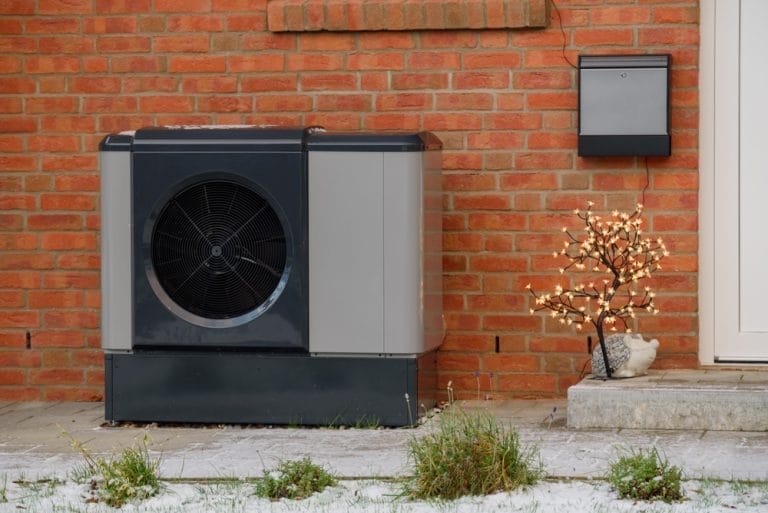 Luftwärmepumpe vor einem Neubau